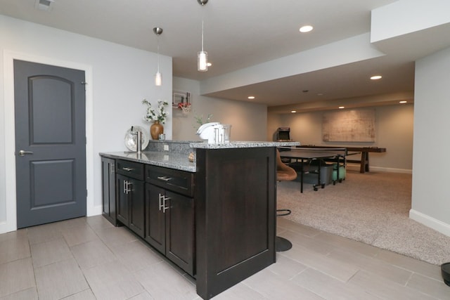 122 Woodside Blvd, Lexington, OH 44904 - kitchen with a breakfast bar, light stone counters, a peninsula, pendant lighting, and baseboards