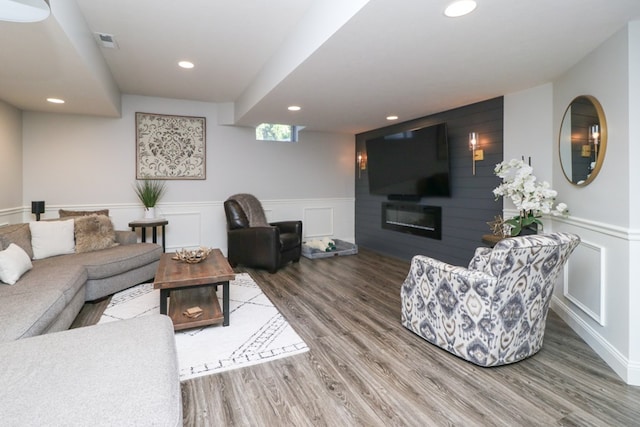122 Woodside Blvd, Lexington, OH 44904 - living room featuring wood finished floors, recessed lighting, a glass covered fireplace, a wainscoted wall, and a decorative wall