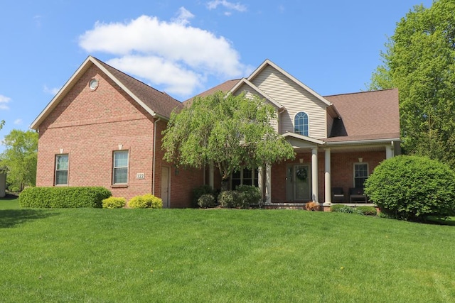 122 Woodside Blvd, Lexington, OH 44904 - view of front facade with brick siding, a front yard, and a porch