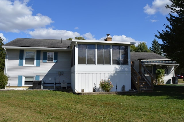 back of property featuring a sunroom and a yard