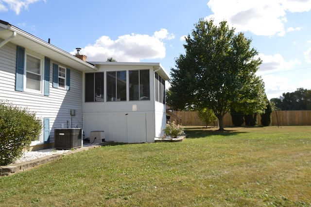 view of yard featuring a sunroom and central AC