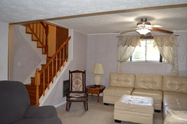 living room featuring a textured ceiling, carpet floors, ceiling fan, and ornamental molding