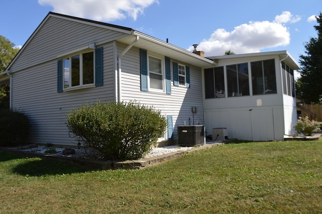 view of home's exterior featuring a sunroom, central air condition unit, and a yard