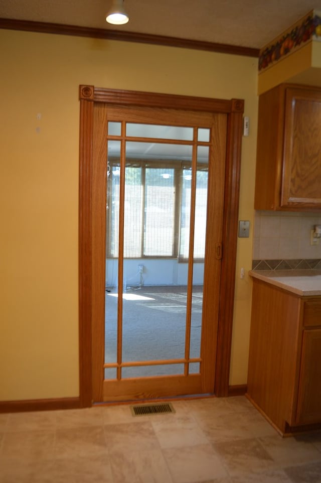 doorway to outside with crown molding