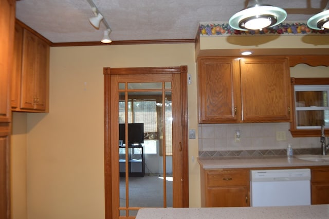 kitchen featuring backsplash, sink, dishwasher, and ornamental molding