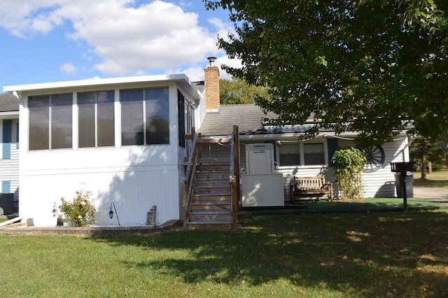 view of front of house with a front yard and a sunroom