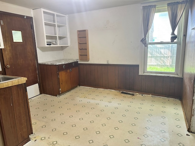 318 S Washington St, Galion, OH 44833 - kitchen with a wainscoted wall, open shelves, light flooring, light countertops, and wooden walls