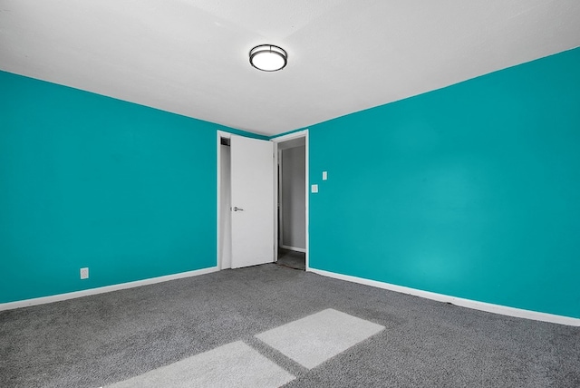 spare room featuring carpet flooring, a textured ceiling, and baseboards