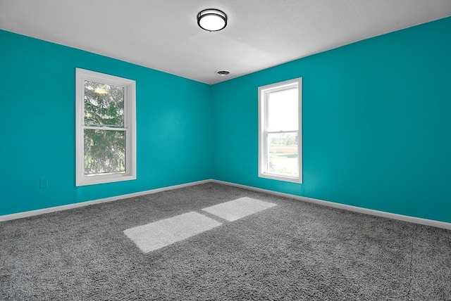 carpeted empty room featuring visible vents, a textured ceiling, and baseboards