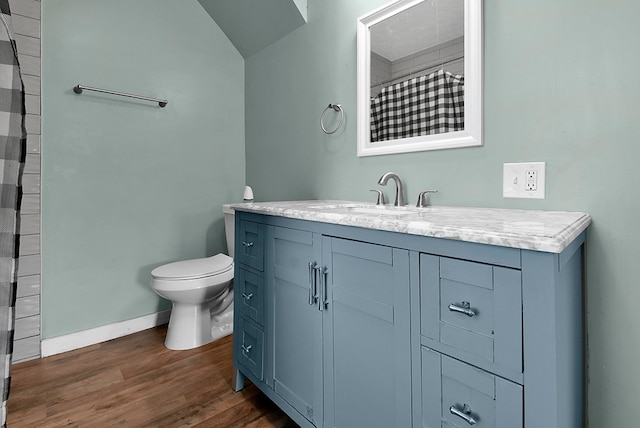 bathroom with toilet, vanity, wood finished floors, a shower with curtain, and baseboards