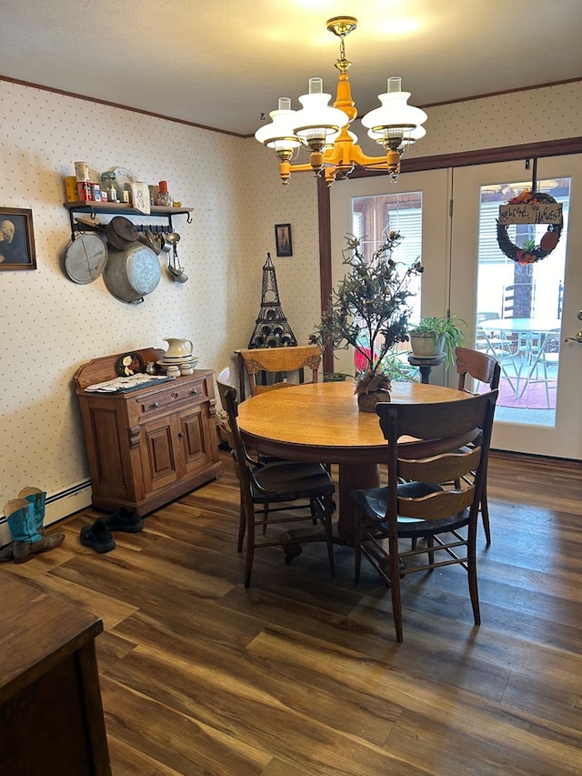 dining room featuring baseboard heating, dark hardwood / wood-style floors, ornamental molding, and a notable chandelier