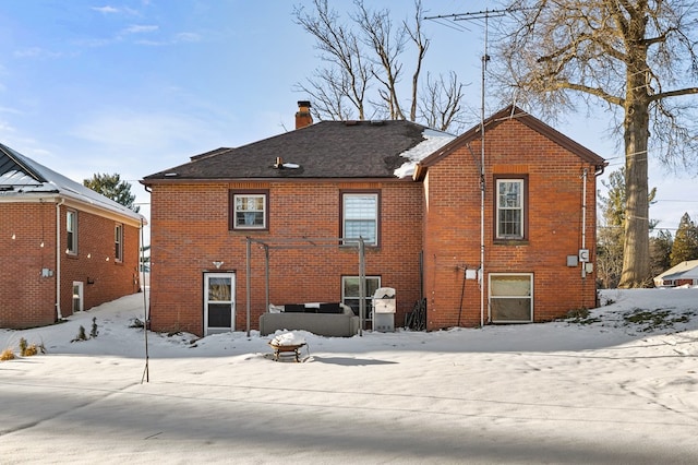 view of snow covered back of property