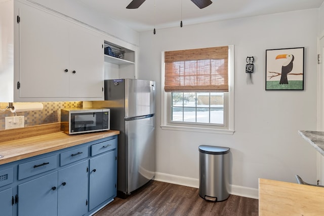 kitchen featuring ceiling fan, backsplash, blue cabinetry, stainless steel appliances, and dark hardwood / wood-style flooring