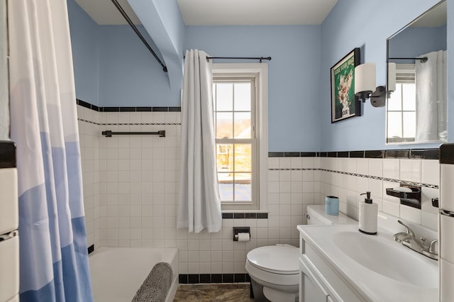 bathroom with toilet, a wealth of natural light, tile walls, and vanity