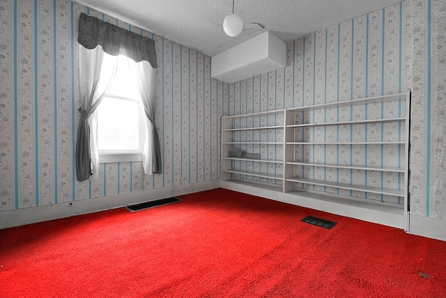 unfurnished room with carpet flooring and a textured ceiling