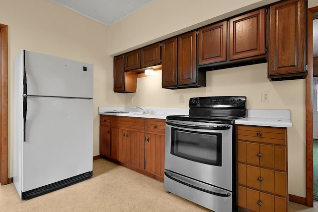 kitchen with stainless steel range with electric stovetop, white refrigerator, and sink