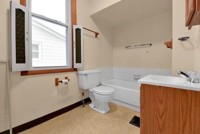 bathroom with a tub to relax in, a wealth of natural light, vanity, and toilet