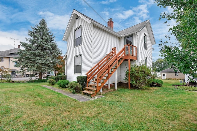 rear view of property with a lawn and a deck