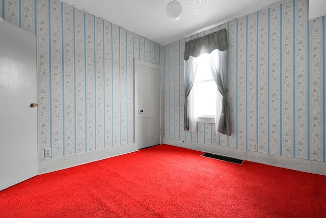 unfurnished room featuring carpet floors and a textured ceiling