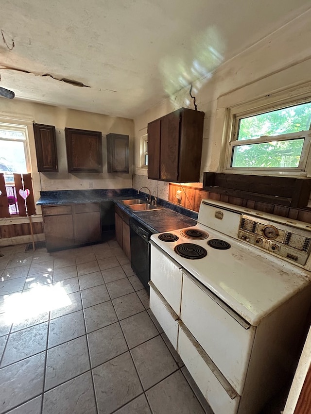 1221 N Sandusky Ave, Bucyrus, OH 44820 - kitchen featuring black dishwasher, dark countertops, dark brown cabinets, and light tile patterned floors