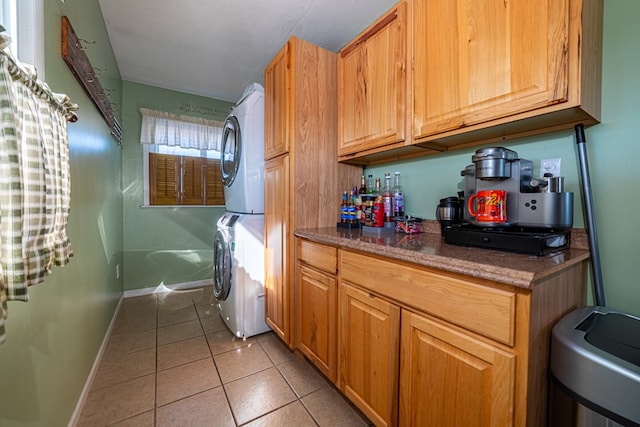 kitchen with stacked washer / dryer and light tile patterned flooring