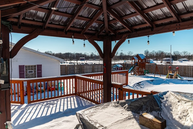 snow covered deck featuring a playground