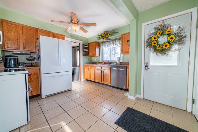 kitchen with white fridge, light tile patterned floors, ceiling fan, electric range oven, and stainless steel dishwasher