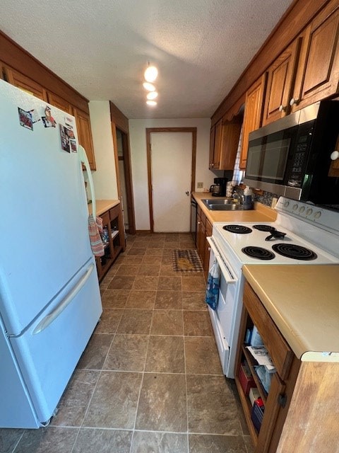 2415 State Route 96, Ashland, OH 44805 - kitchen featuring white appliances, brown cabinetry, a textured ceiling, and light countertops