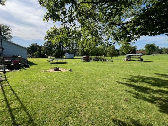 2415 State Route 96, Ashland, OH 44805 - view of green lawn featuring an outdoor fire pit and a storage shed