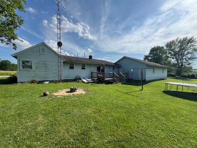 2415 State Route 96, Ashland, OH 44805 - rear view of property featuring a deck, a lawn, a fire pit, and a trampoline
