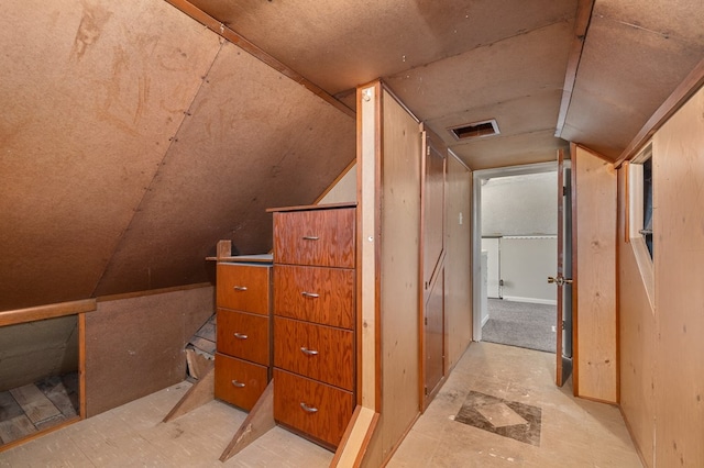 corridor with visible vents and vaulted ceiling