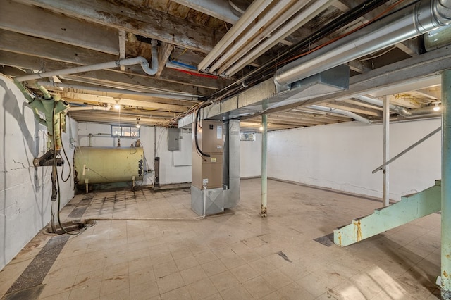 unfinished basement featuring electric panel, heating unit, heating fuel, and tile patterned floors