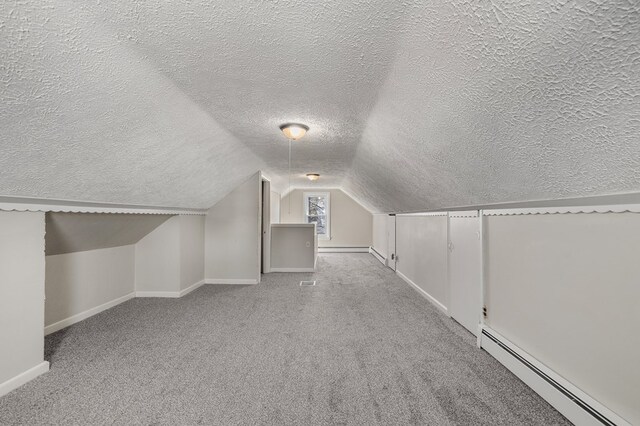 additional living space with vaulted ceiling, baseboards, baseboard heating, and carpet floors