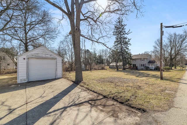 view of yard featuring a detached garage, an outbuilding, and driveway