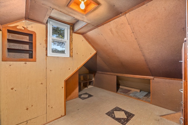additional living space featuring tile patterned floors, wooden walls, and vaulted ceiling