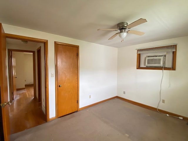 unfurnished bedroom with ceiling fan, carpet floors, and a wall unit AC