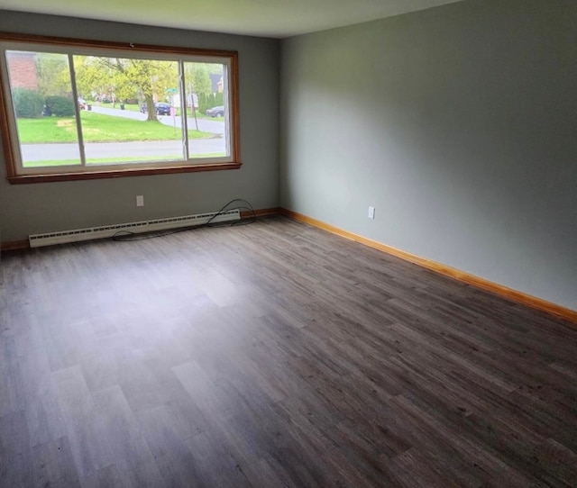 unfurnished room with a baseboard heating unit and hardwood / wood-style floors