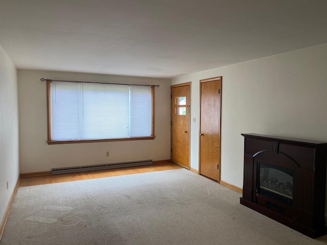 unfurnished living room with baseboard heating and light colored carpet