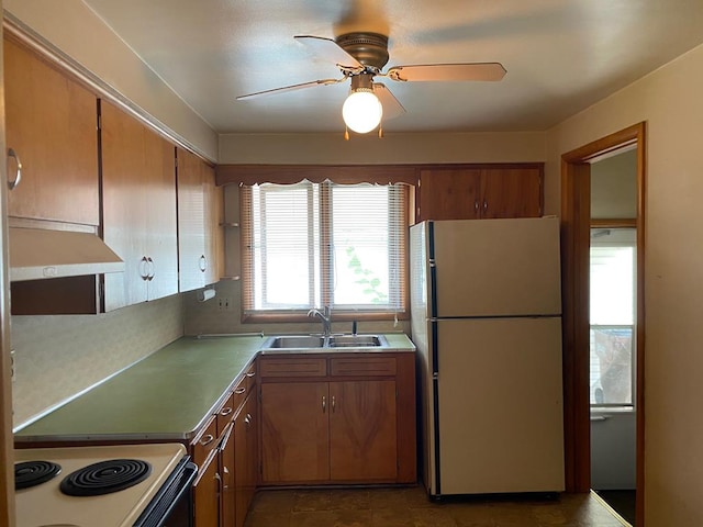 kitchen with white appliances, dark tile patterned floors, extractor fan, sink, and ceiling fan