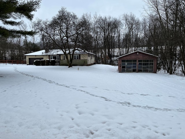 yard layered in snow featuring a garage