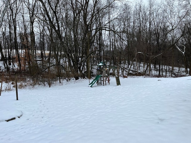 yard covered in snow with a playground