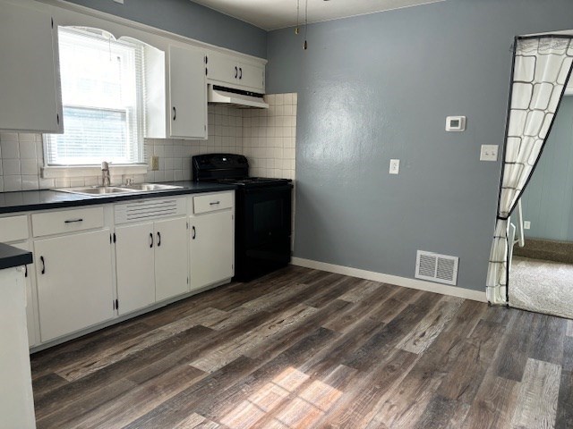 434 Michigan Ave, Mansfield, OH 44905 - kitchen with black range with electric stovetop, custom range hood, dark countertops, dark wood-style flooring, and decorative backsplash