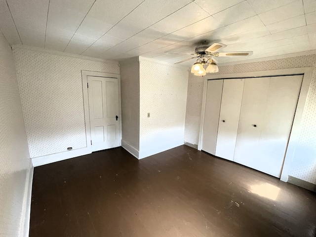 5655 Lime Rd, Galion, OH 44833 - unfurnished bedroom with wallpapered walls, dark wood finished floors, a ceiling fan, and a closet