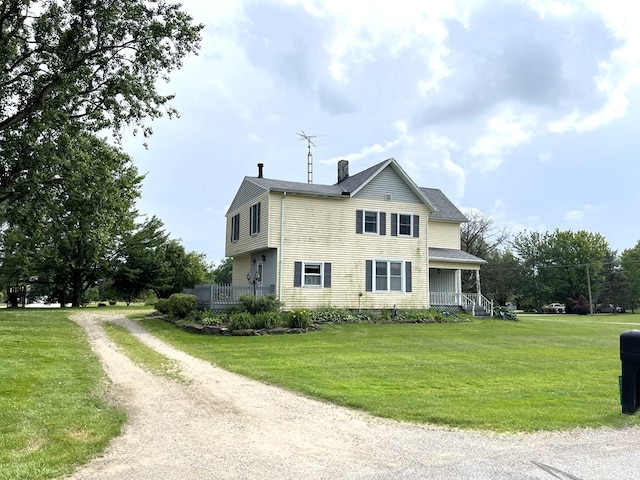 5655 Lime Rd, Galion, OH 44833 - view of side of property featuring driveway, a chimney, a lawn, and a porch