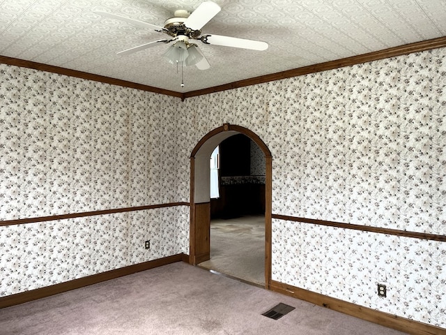5655 Lime Rd, Galion, OH 44833 - spare room featuring ornamental molding, arched walkways, carpet, a ceiling fan, and wallpapered walls