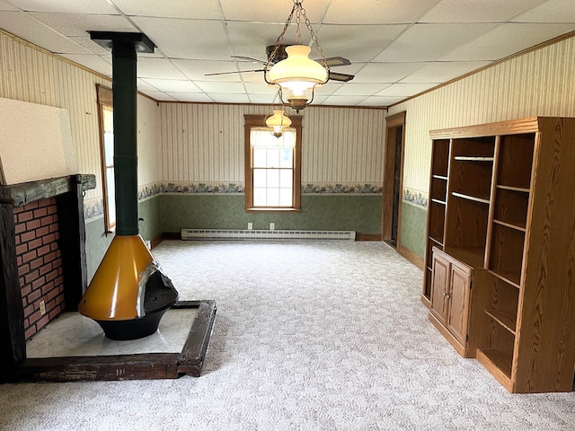 5655 Lime Rd, Galion, OH 44833 - unfurnished living room with a wood stove, baseboard heating, carpet flooring, a drop ceiling, and wallpapered walls