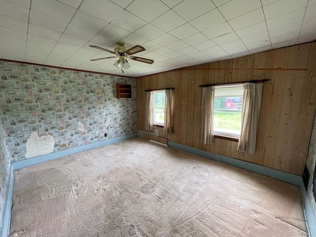 5655 Lime Rd, Galion, OH 44833 - spare room featuring a ceiling fan, light carpet, and wood walls