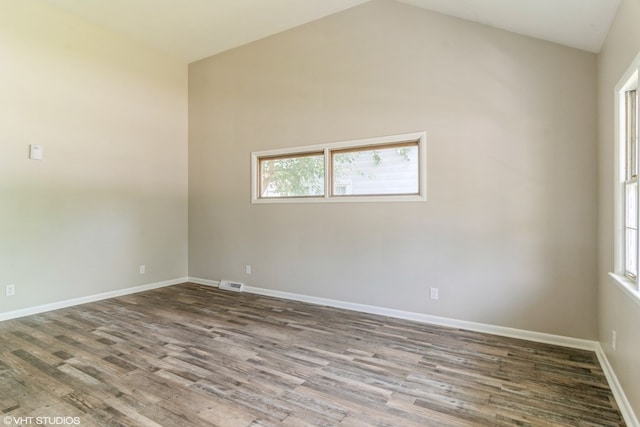 empty room featuring wood-type flooring and lofted ceiling