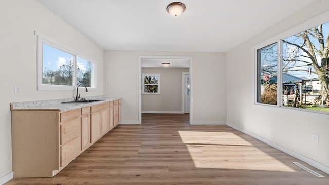 kitchen featuring light brown cabinetry, light hardwood / wood-style flooring, and sink