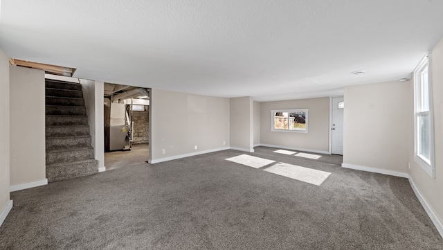 unfurnished living room featuring carpet flooring and heating unit